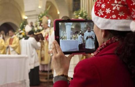 A Christian worshipper used her iPad to take photos during a Christmas mass at the Church of the Nativity.
